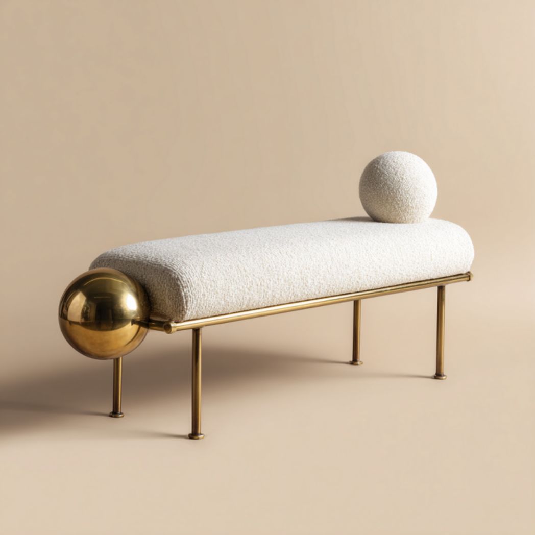 Banco tapizado color marfil con esfera metálica decorativa y cojín redondo